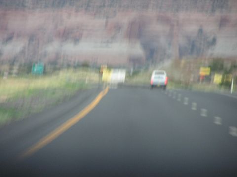 1993 Ford Taurus - A white SUV travels down a highway, with distant red rock formations visible.