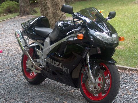 2002 Suzuki TL1000R - A black Suzuki motorcycle with red rims and a Yoshimura exhaust is parked on a gravel surface.