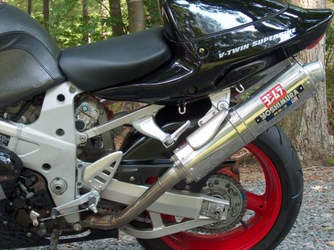 2002 Suzuki TL1000R - A close-up view of a motorcycle's V-Twin engine exhaust system and red-painted rear wheel.
