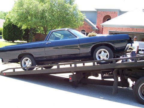 1969 Ford Ranchero - A 1969 Ford Ranchero is loaded onto a flatbed tow truck for transport.