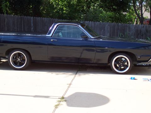 1969 Ford Ranchero - This vehicle features a two-tone paint scheme with a dark blue body and a silver roofline trim.