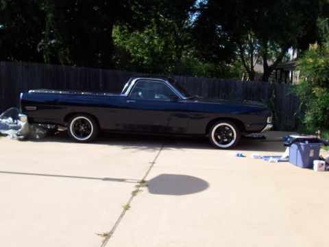 1969 Ford Ranchero - A dark blue 1969 Ford Ranchero pickup truck is parked on a concrete driveway.