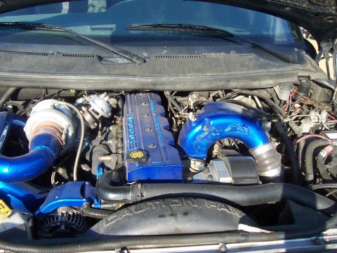 1994 Ford F-150 - Close-up of a modified Dodge Cummins engine, a large turbo and custom blue intake plumbing.