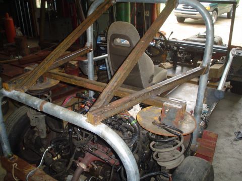 1981 Ford Bronco - This custom off-road vehicle's interior is visible, showing a roll cage and exposed engine parts.