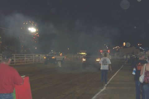1994 Ford F-150 - Trucks compete on a dirt track under the night sky, with a Ferris wheel visible.