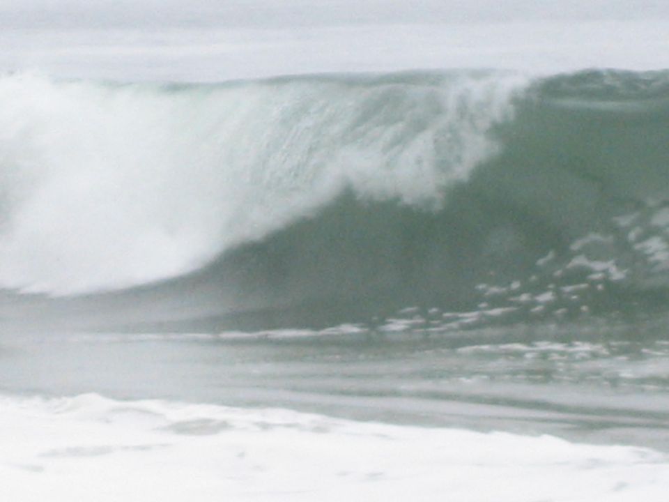 large breaking ocean wave curling over with whitewater and spray
