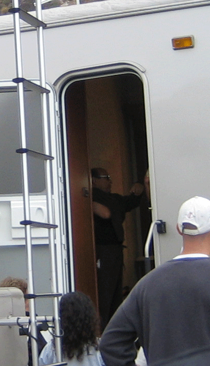 1990 Ford Bronco - person stands in the open doorway of a white trailer next to a side ladder as others look on.