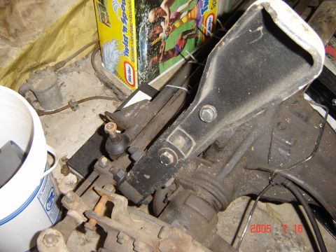 1993 Ford Bronco - A vehicle's axle assembly is shown with various mechanical parts and a bucket in the background.