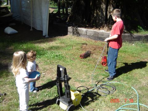 1993 Ford Bronco - Two children and a pressure washer are in a yard with car springs on the ground.