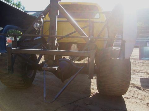 1994 Ford F-150 - Custom truck rear end with oversized tires and visible suspension and axle parts.
