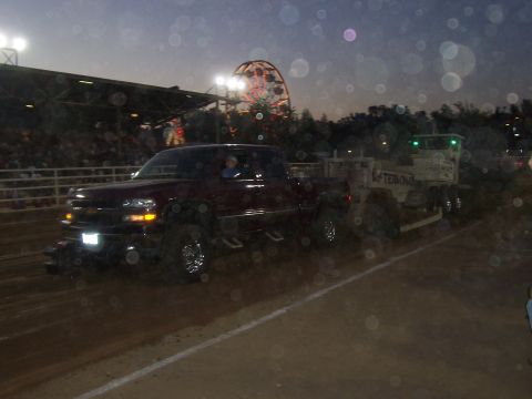 1994 Ford F-150 - A maroon pickup truck is seen pulling a trailer at an event with a Ferris wheel in the background.