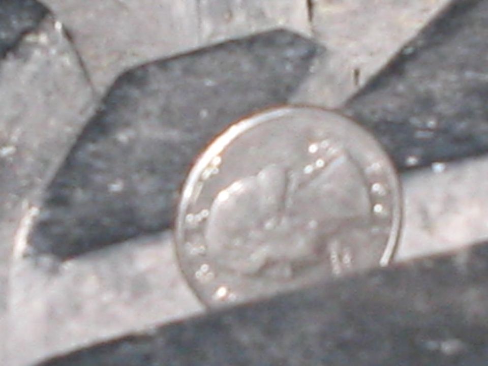 Close-up of a dime coin resting on a textured gray surface