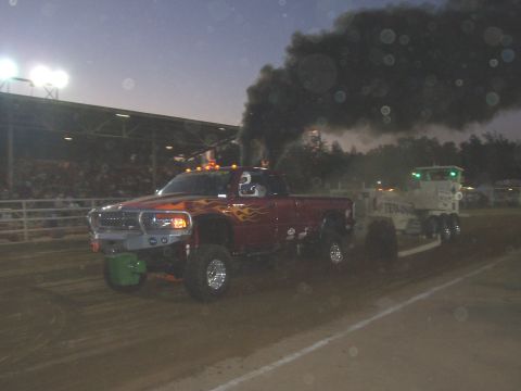 1994 Ford F-150 - A souped-up pickup truck is seen emitting a large cloud of black smoke while participating in an event.