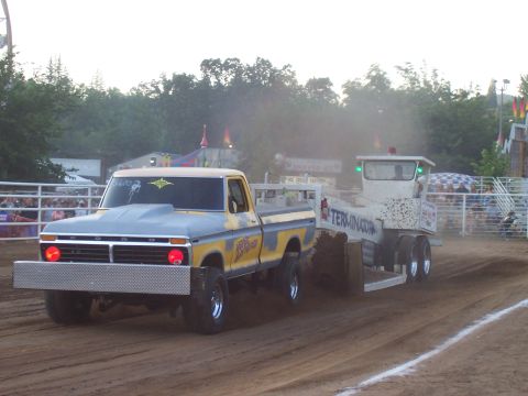 1994 Ford F-150 - A modified pickup truck competes in a tractor pull event, dragging a weighted sled.