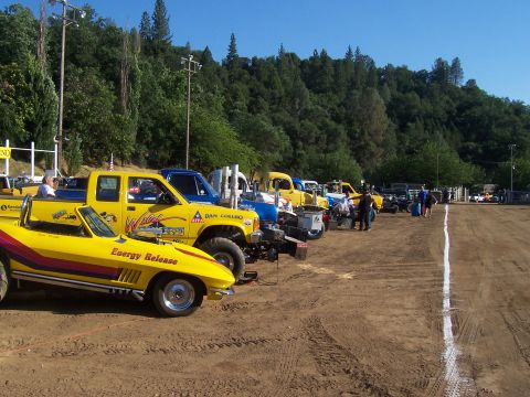 1994 Ford F-150 - Several trucks and a yellow Corvette are parked at an outdoor event.