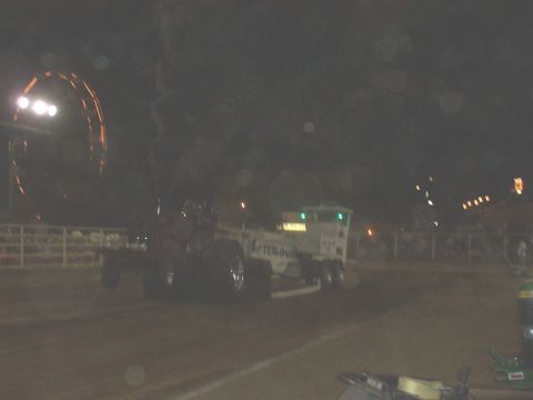 1994 Ford F-150 - A modified tractor pull truck competes on a dirt track under stadium lights at night.