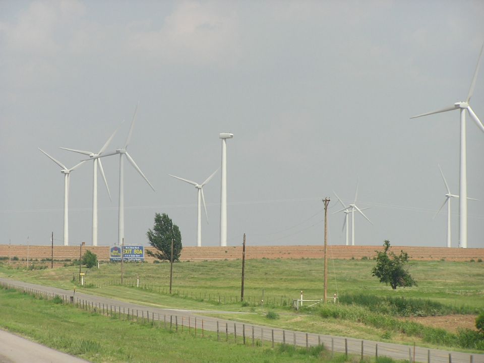 wind turbines in a field with a road and a sign for exit 804