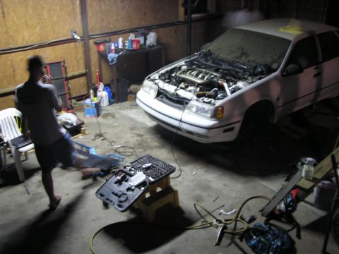 1993 Ford Taurus - A white 1993 Ford Taurus sedan is parked in a garage with its hood open, showing the engine.
