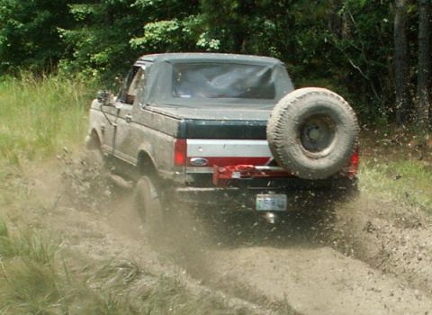 1988 Ford Bronco - This 1988 Ford Bronco kicks up mud as it navigates a trail.