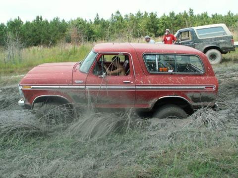 1988 Ford Bronco - A red 1978 Ford Bronco is stuck in the mud with another vehicle behind it.