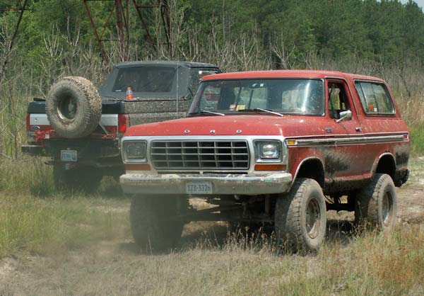 Red Ford Bronco with a prominent grille and a license plate reading XZB-3326
