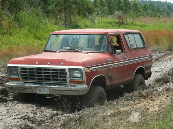 Red 1978 Ford Bronco stuck in mud, license plate XZB-3326