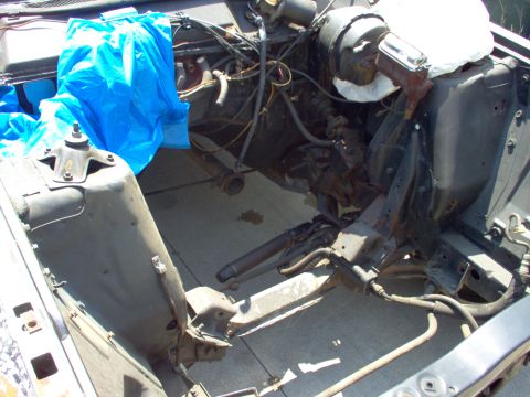 1970 Ford Ranchero - The engine bay of a 1970 Ford Ranchero shows the brake master cylinder and a blue tarp covering some engine parts.