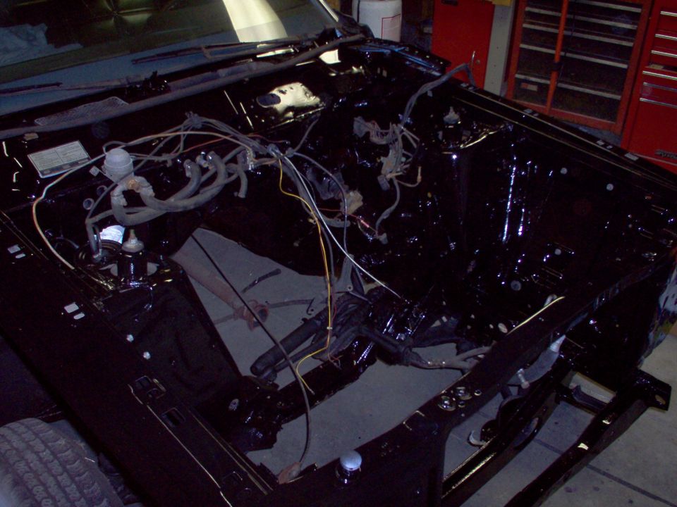Freshly painted black empty engine bay of stripped classic car