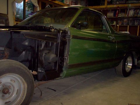 1970 Ford Ranchero - A green 1970 Ford Ranchero is shown in a garage with its front fender removed, revealing the chassis and engine bay.