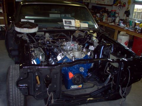 1970 Ford Ranchero - The front end of a car is disassembled, revealing the engine and surrounding components in a workshop.