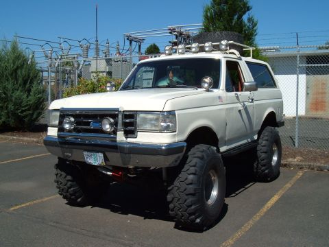 1989 Ford Bronco - White 1989 Ford Bronco lifted with off-road tires and roof rack.