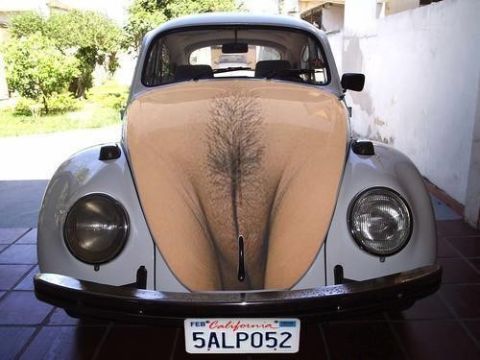 1990 Ford Bronco - white classic Volkswagen Beetle photographed head-on, its hood given a humorous painted treatment, with a California plate.