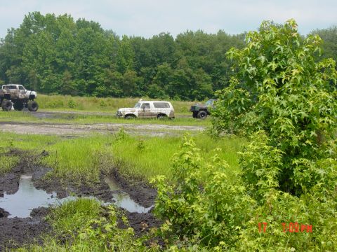 1995 Dodge 1500 - Multiple off-road vehicles traverse a muddy track, their capabilities in challenging terrain.