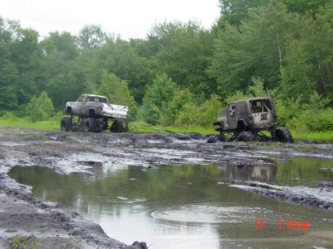 1995 Dodge 1500 - Two heavily modified off-road vehicles are stuck deep in the mud after an off-roading excursion.