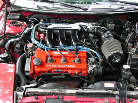 1997 Ford Probe - Close-up of a red Mazda V6 DOHC 24-valve engine with blue spark plug wires and an aftermarket air intake.