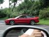 1997 Ford Probe - Red 1997 Ford Probe parked curbside, captured from another vehicle's side mirror.