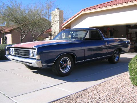1969 Ford Ranchero - A blue 1969 Ford Ranchero with a contrasting red hood sits parked in a suburban driveway.