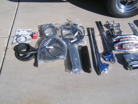 1969 Ford Ranchero - Various automotive parts are displayed on a concrete surface, including rubber seals and chrome trim.