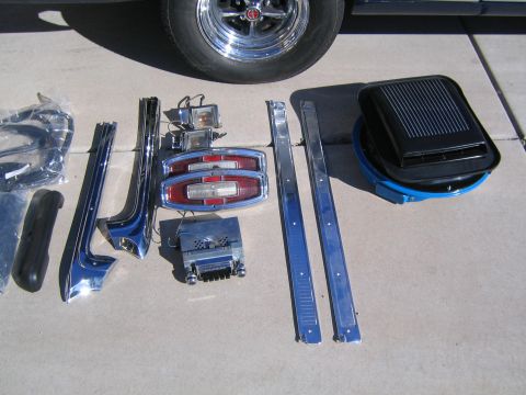 1969 Ford Ranchero - Collection of 1969 Ford Ranchero parts laid out on concrete, including taillights and trim.