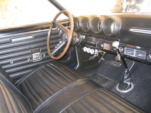 1969 Ford Ranchero - Interior view of a 1969 Ford Ranchero, black vinyl seats and a wood-rimmed steering wheel.