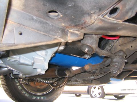 1969 Ford Ranchero - The underside of a vehicle reveals its suspension and exhaust system, with another car in the distance.