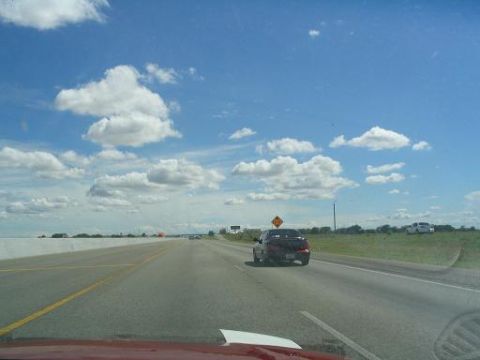 1994 Ford Probe - A 1994 Ford Probe travels down a highway under a partly cloudy sky, with another vehicle visible on the right.