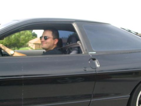 1994 Ford Probe - Driver in sunglasses behind the wheel of a black 1994 Ford Probe.