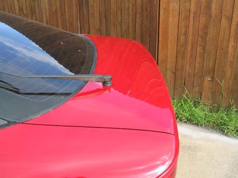 1994 Ford Probe - The rear of a red car is shown with a wooden fence in the background.