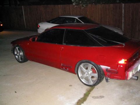 1994 Ford Probe - A red coupe with custom wheels is parked next to a white car.