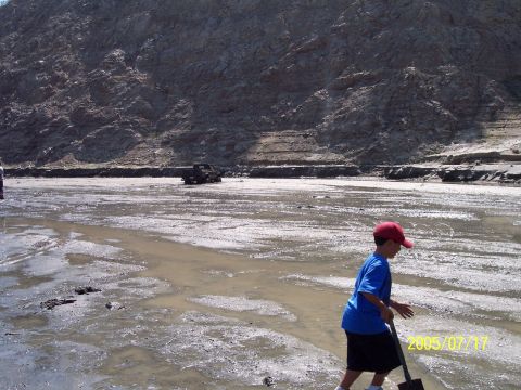 1985 Ford Bronco - A young boy walks across a muddy, dry riverbed with a shovel, while a truck is visible in the distance.