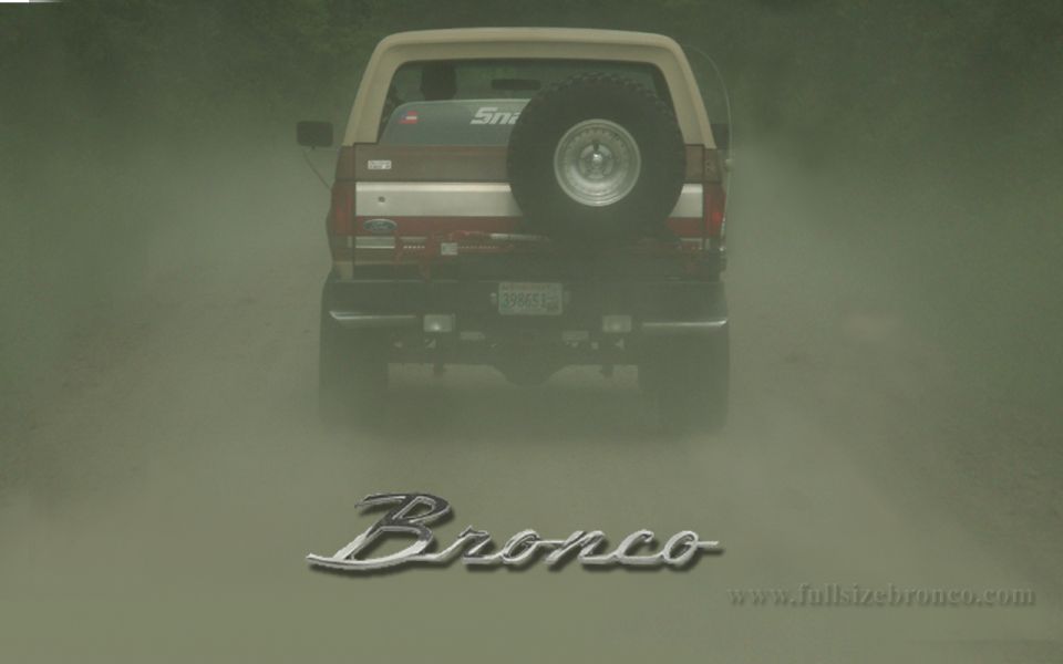 Rear of red and tan Ford Bronco in dust cloud with Bronco script overlay
