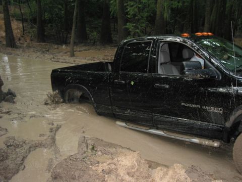 2000 Jeep Grand Cherokee - A black pickup truck navigates a muddy trail, with "Power Wagon" visible on its side.