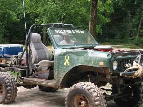 2000 Jeep Grand Cherokee - This heavily modified off-road vehicle has large tires and an exposed engine bay.