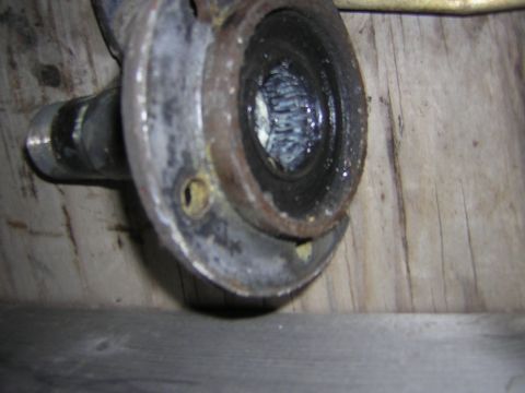 1995 Ford Bronco - A close-up view of a greasy mechanical component, possibly a bearing or seal, against a wooden background.